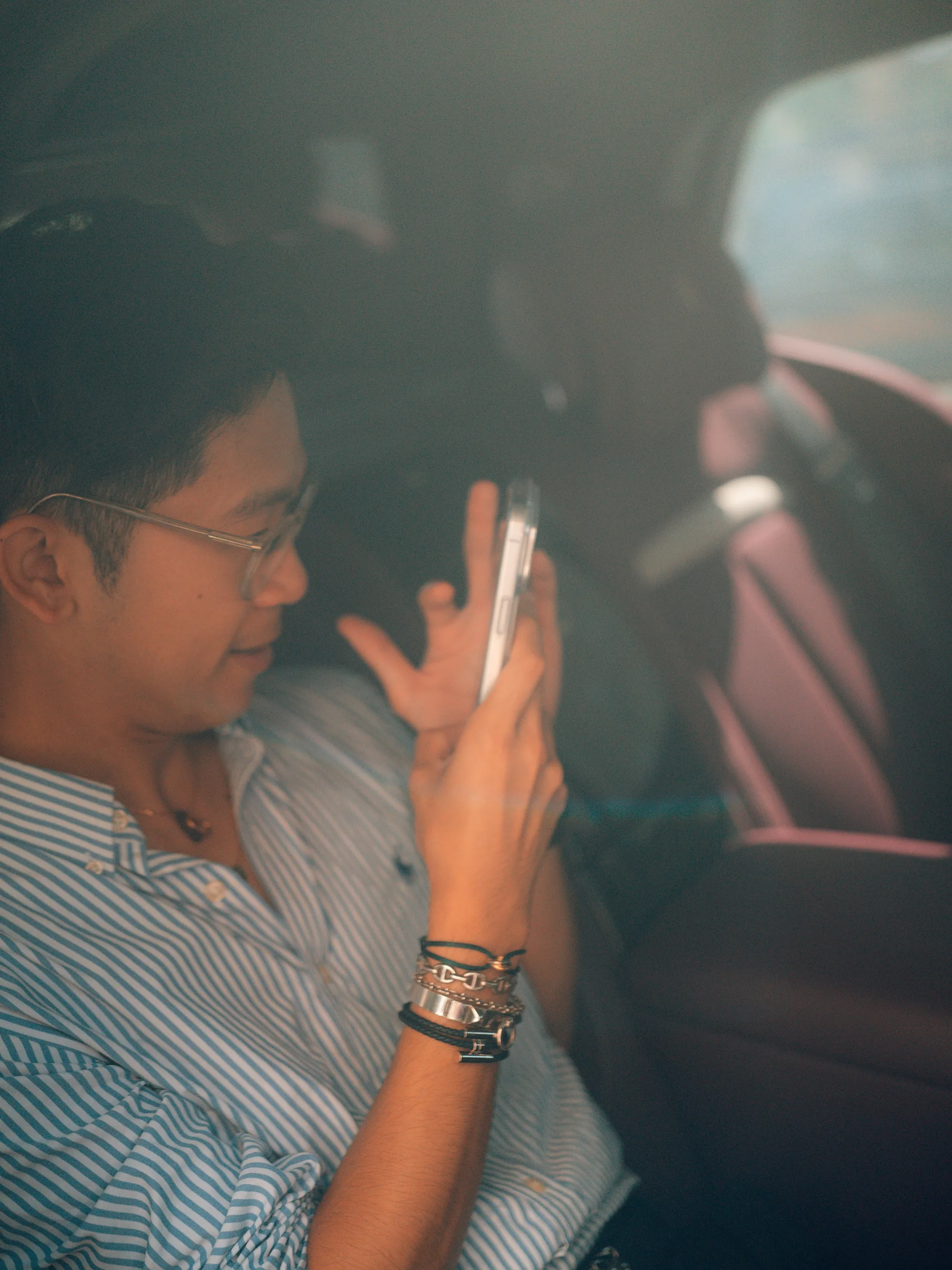A visitor photographs the morning from the passenger seat of a car.